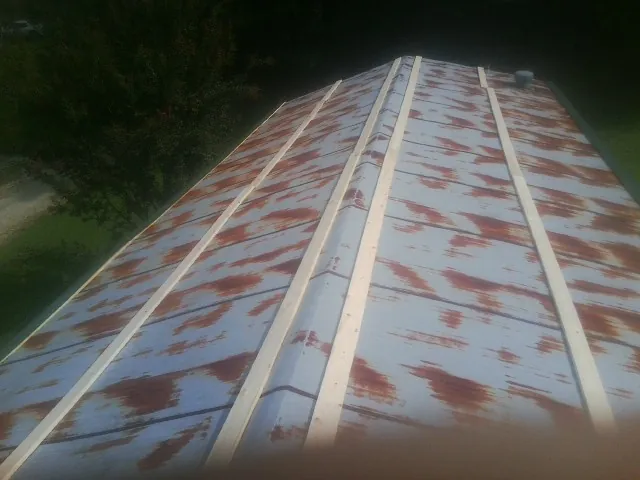 Rusted metal roof panels with new wood purlins before replacement — Storm Damage Roof Repair in Greens Fork by Roofing Brothers