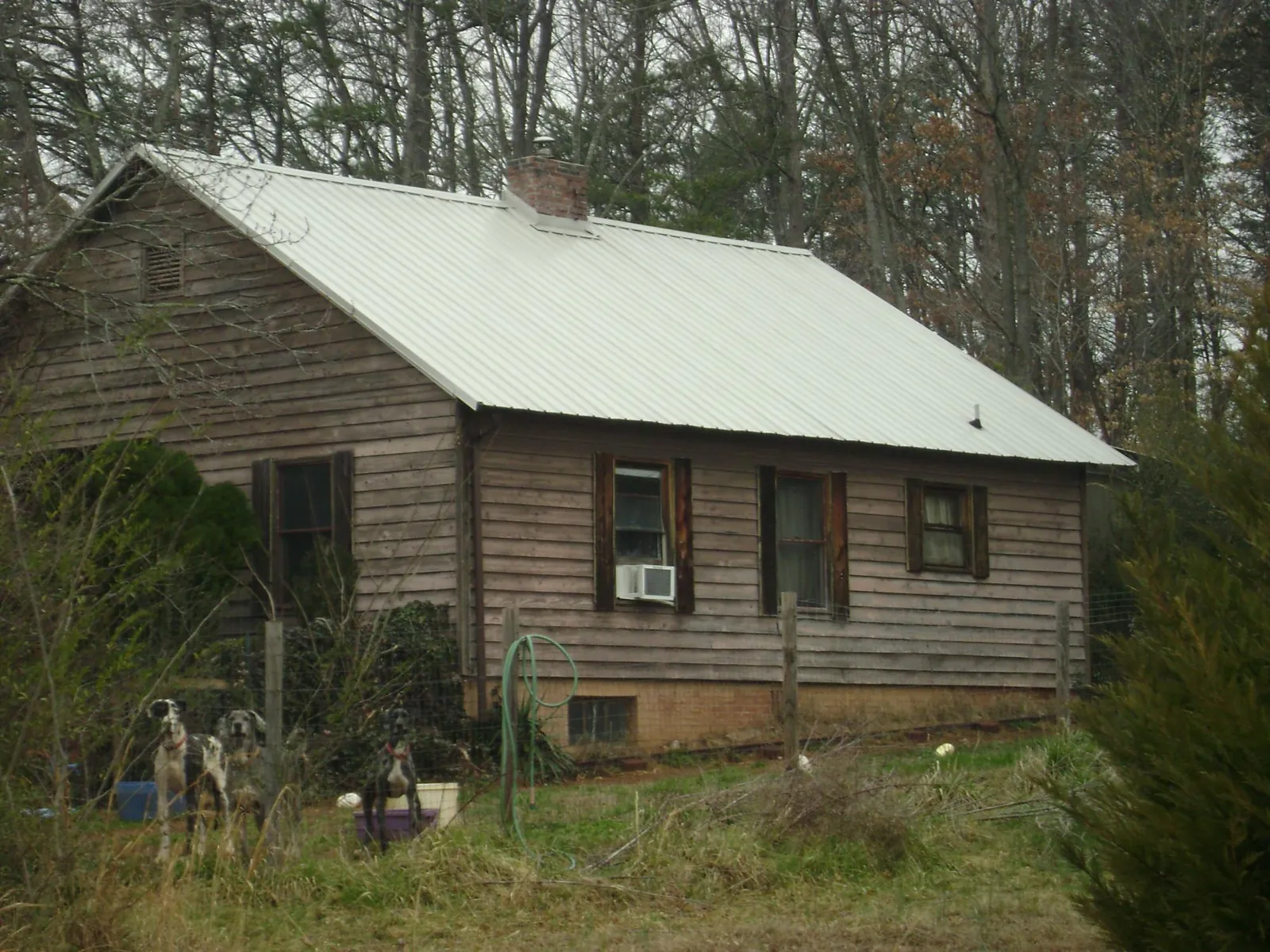 White metal roof on an old wood sided farmhouse, from a Metal Roof Installation job in Greens Fork